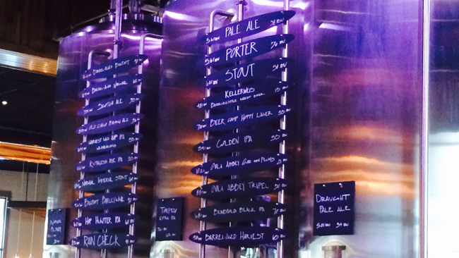 The tap list featured on the impressive bar in the center of the Taproom.