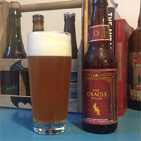 Empty bottle of Bell's The Oracle double IPA next to a glass filled with the same.