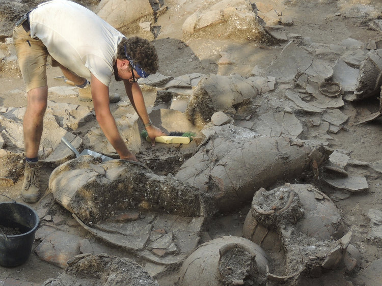 Archaeologist Benjamin Gates unearthing ancient barrels used to age Egyptian beer.