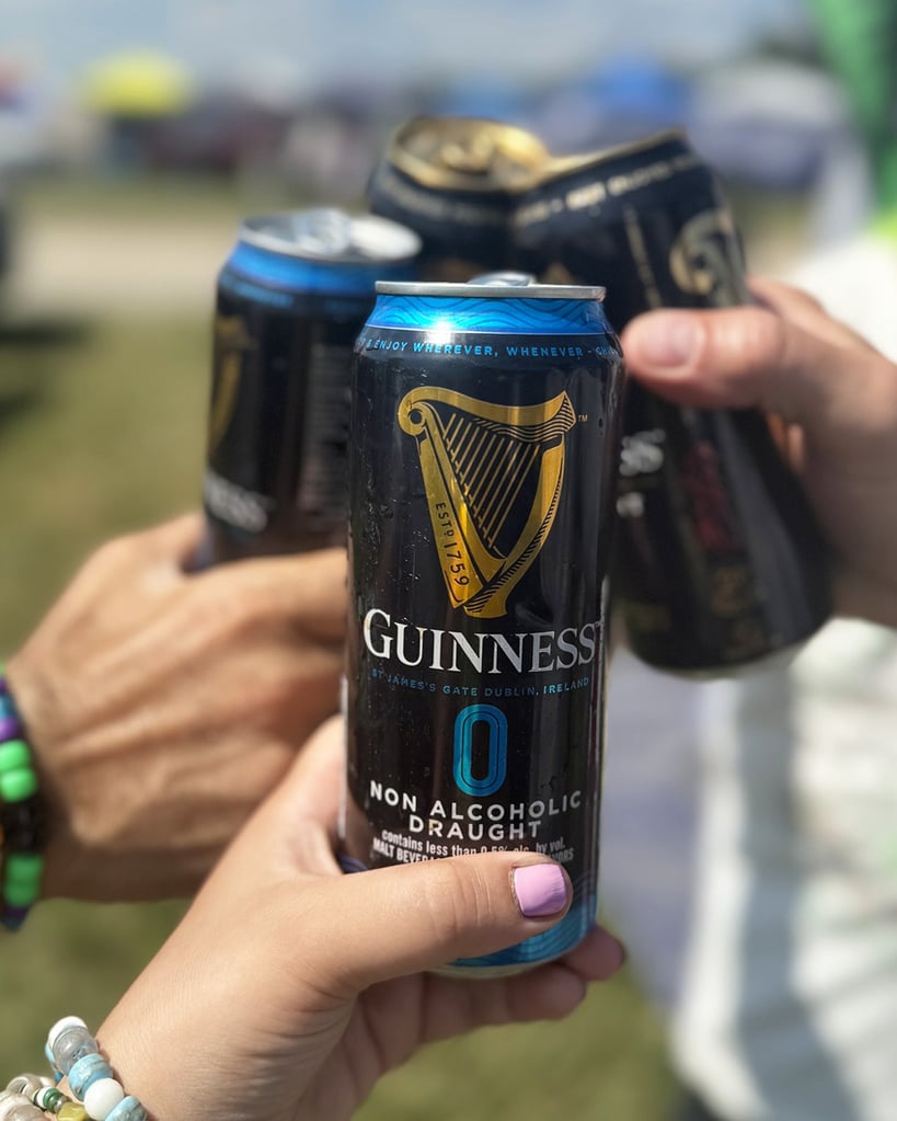 guinness 0 being cheersed with regular guinness by four people
