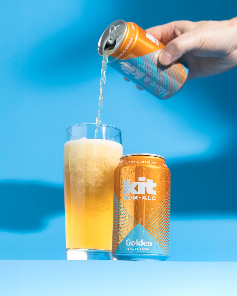 kit na brewing golden non-alcoholic beer being poured into pint glass