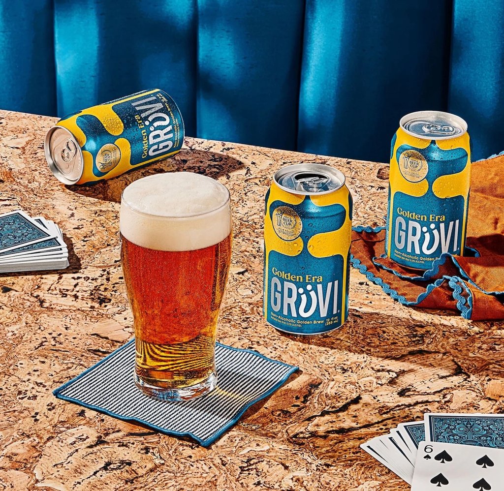 gruvi golden era cans and glass on tabletop next to deck of cards