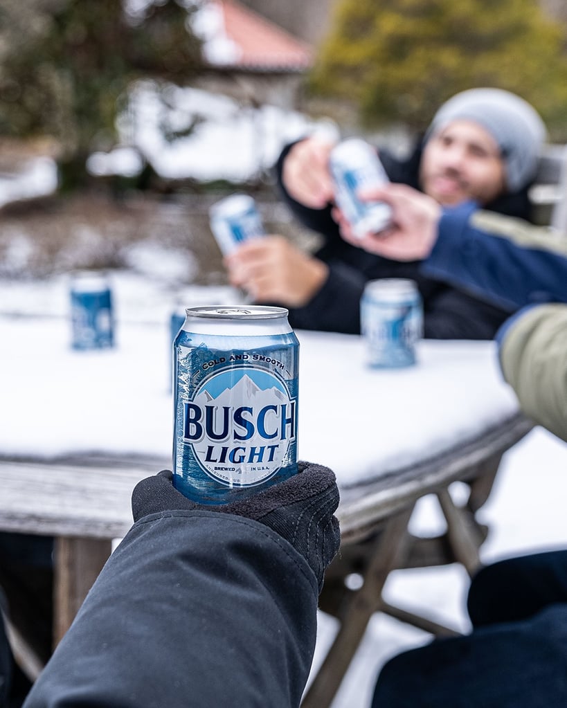 people enjoying busch light outdoors in a snowy environment