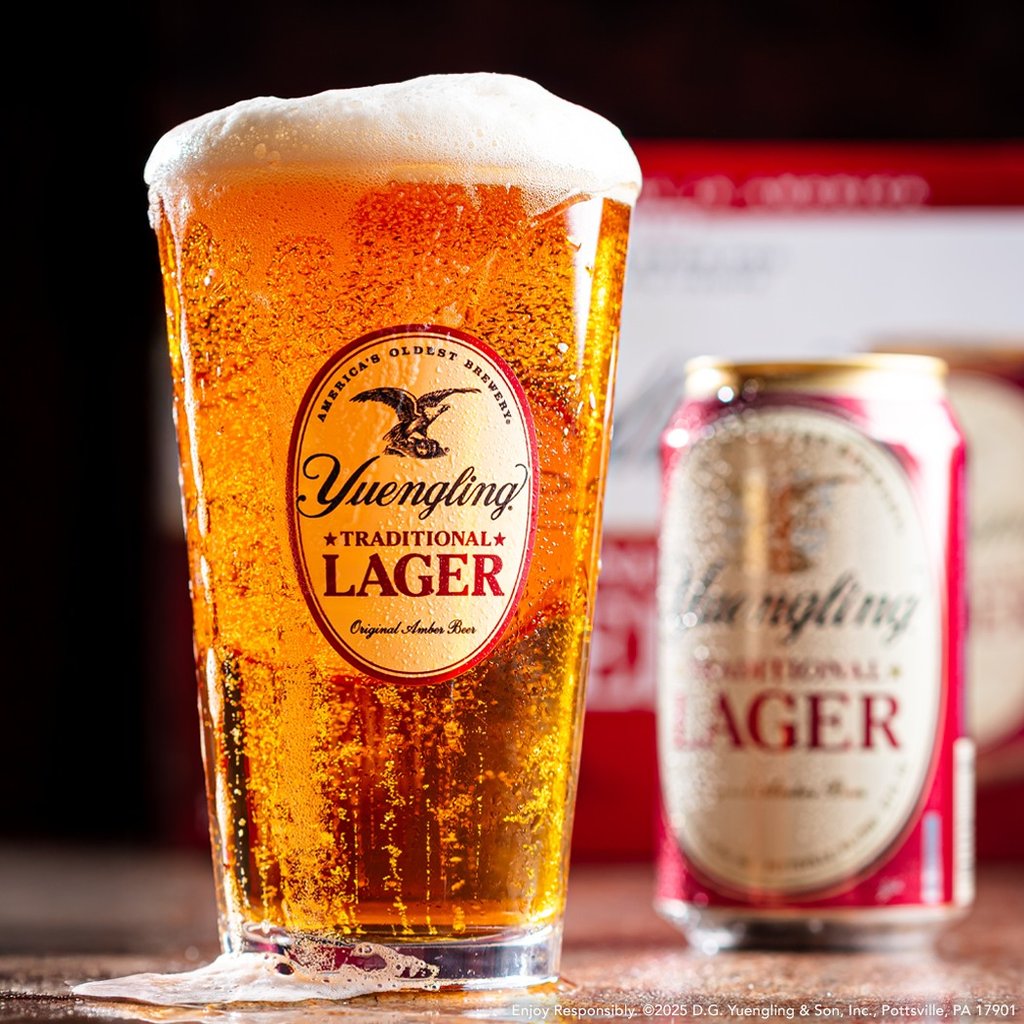 yuengling lager can and frothing glass in front of 12-pack of beer