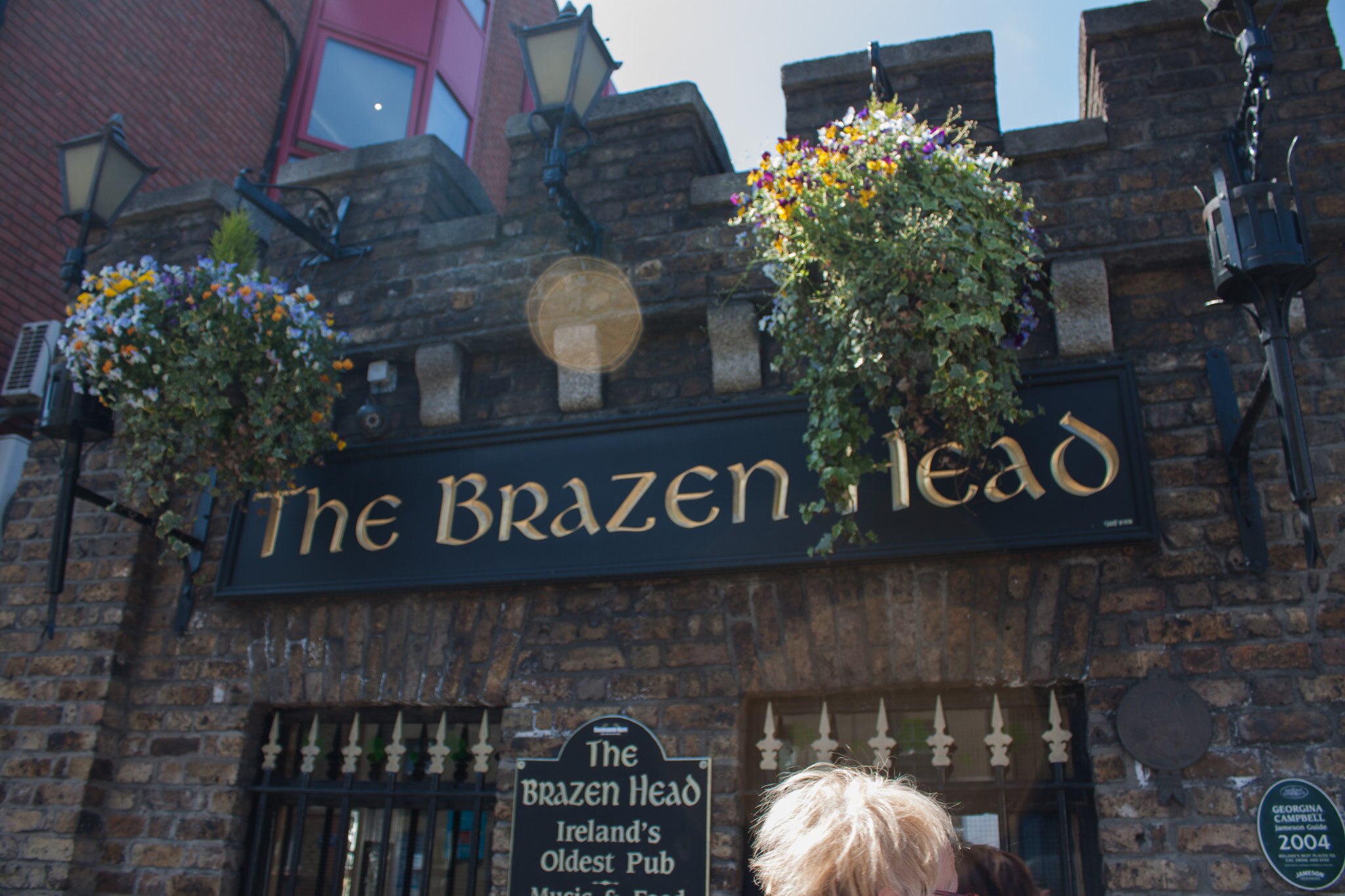 Exterior view of The Brazen Head, made of brick with a sign advertising "Ireland's Oldest Pub."