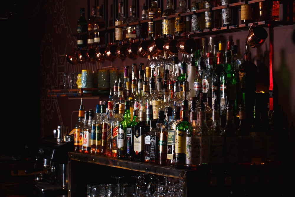 The interior of a bar, with shelves full of liquor bottles.