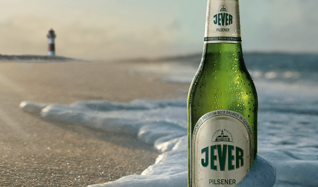 Jever Pilsener beer bottle on a beach.