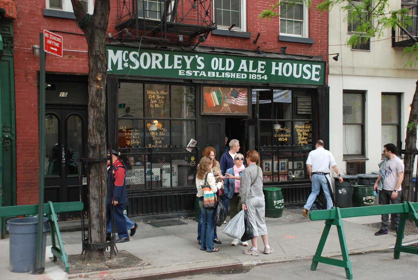 Lively exterior of McSorley's Old Ale House with people surrounding the entrance.