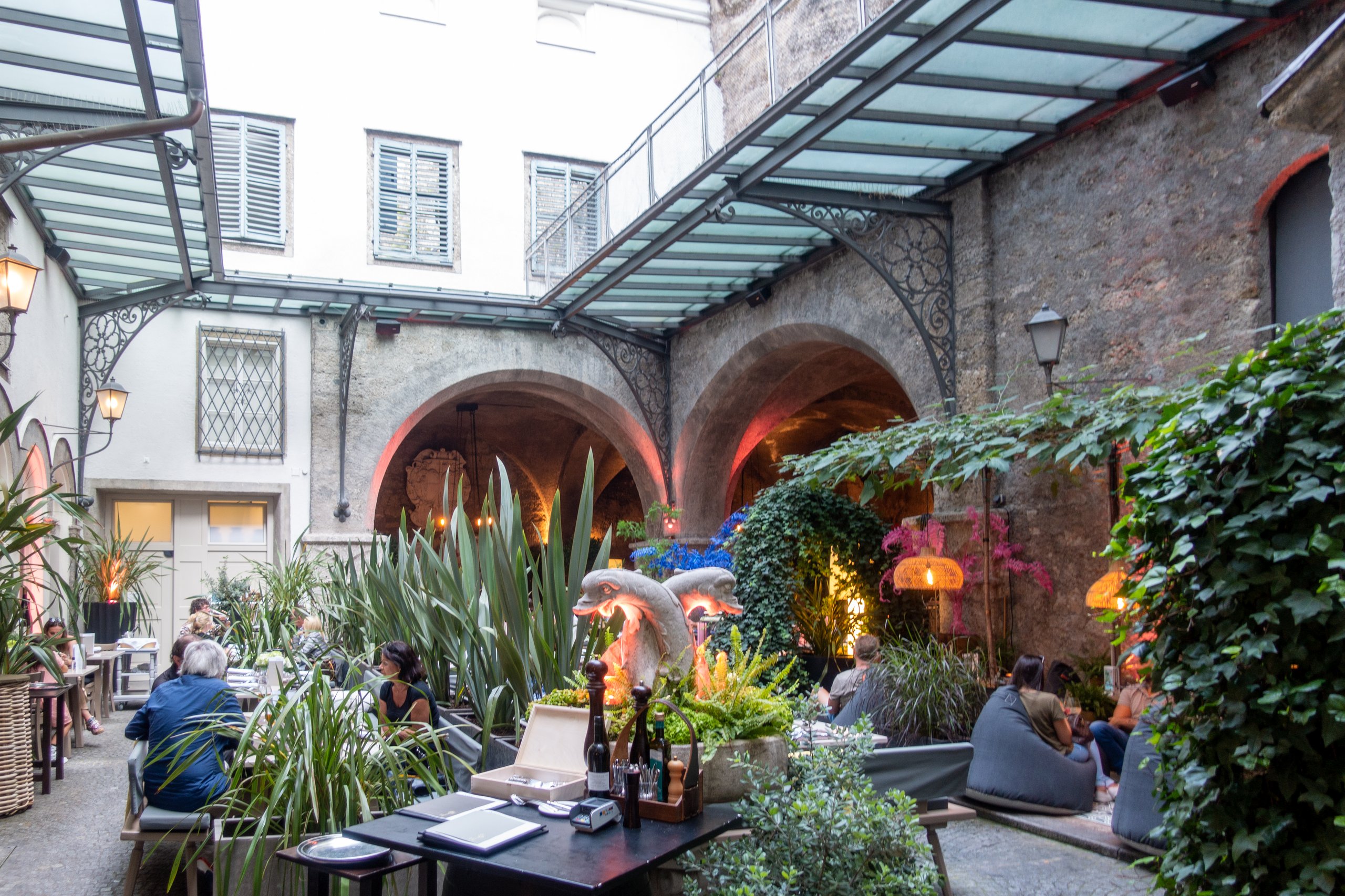 Austria's oldest bar, St Peter Stiftskulinarium's outdoor seating with lots of plants.