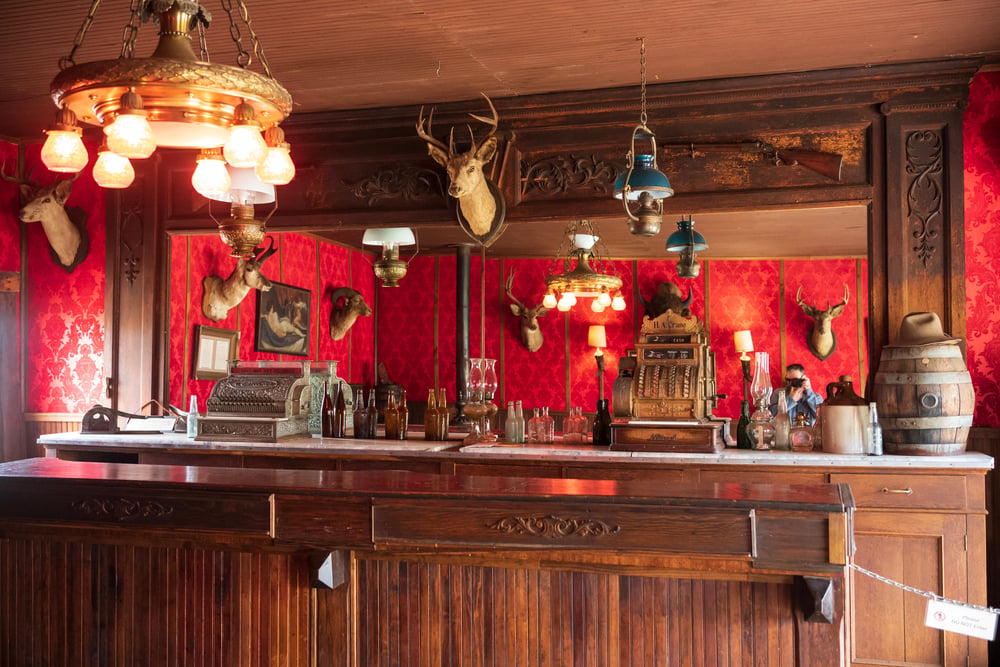Interior of one of the oldest bars in USA, with a cared wood bar surface and red walls.