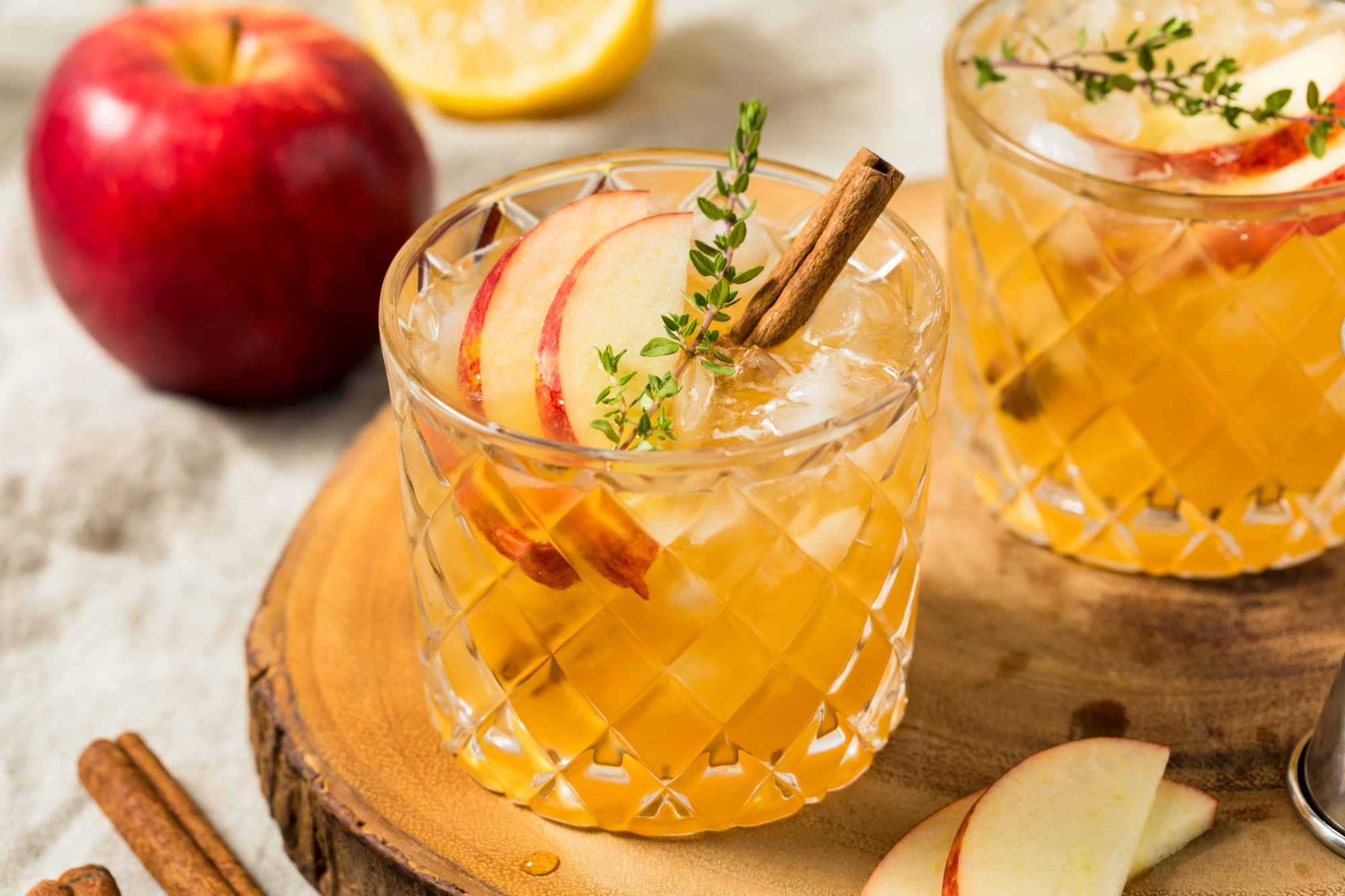 Glass of "fall of the porch" autumn seasonal cocktail with apple, cinnamon, cider, bourbon and maple syrup.