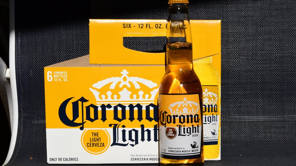 corona light bottle next to empty six-pack outside