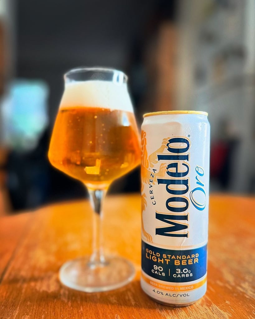 can of modelo oro next to teku glass