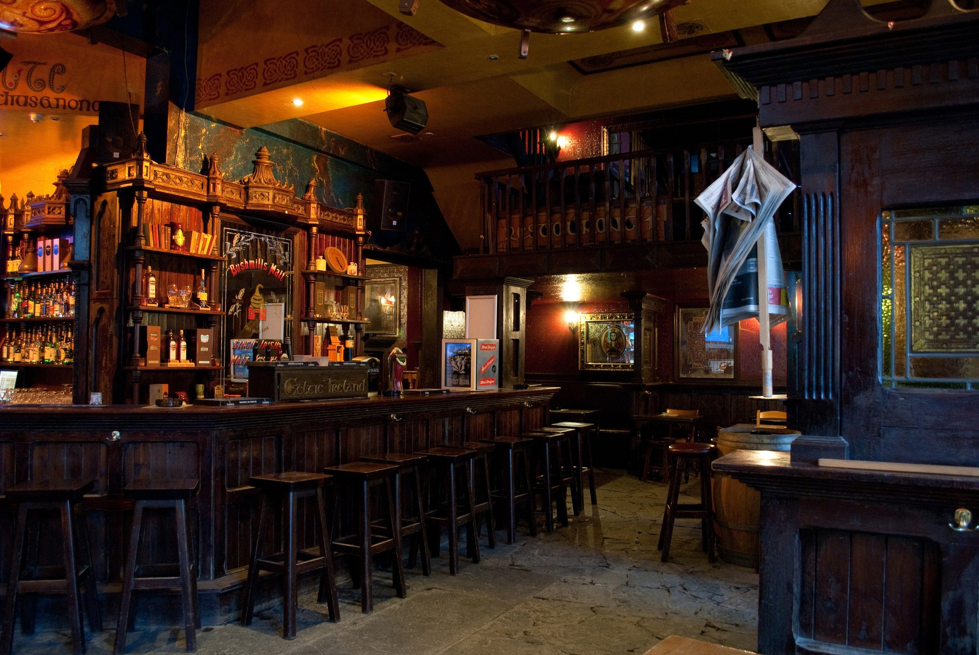 Old, cozy bar in Ireland with mood lighting and wooden fixtures.
