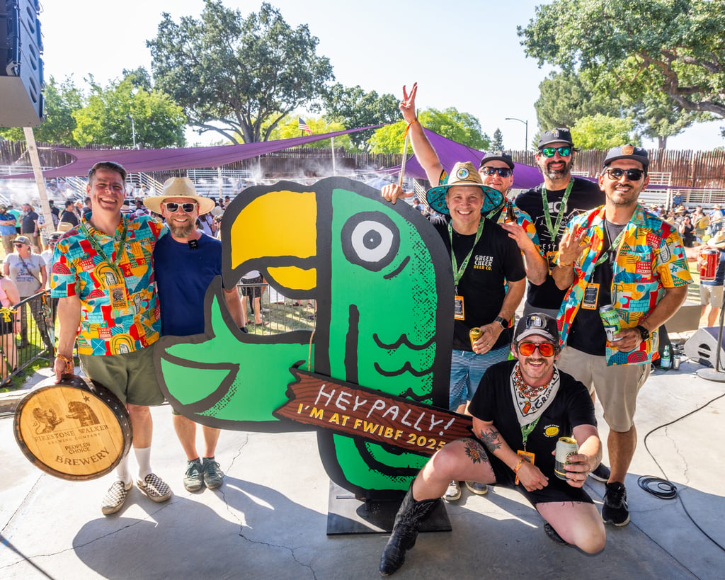Group of people surrounding cutout of a parrot