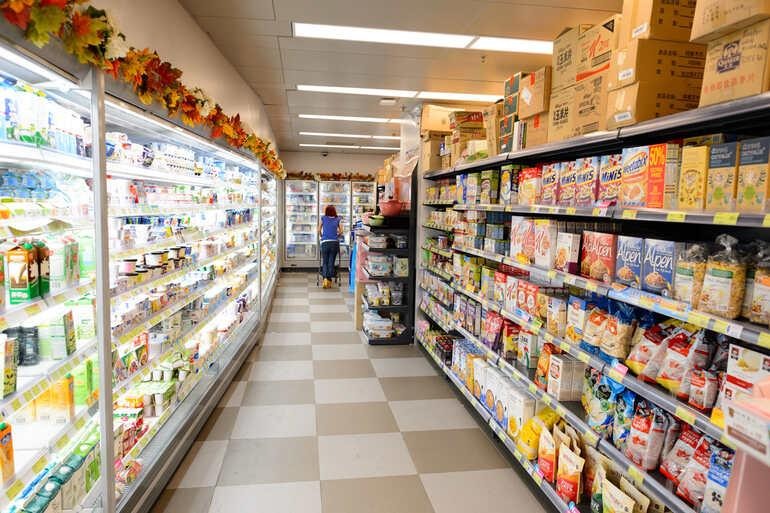 Grocery store aisle showcasing refrigerated and packaged food products, illustrating cold chain logistics and storage across the U.S. food supply system.