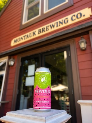 montauk brewing anniversary beer can set against the brewery's entry