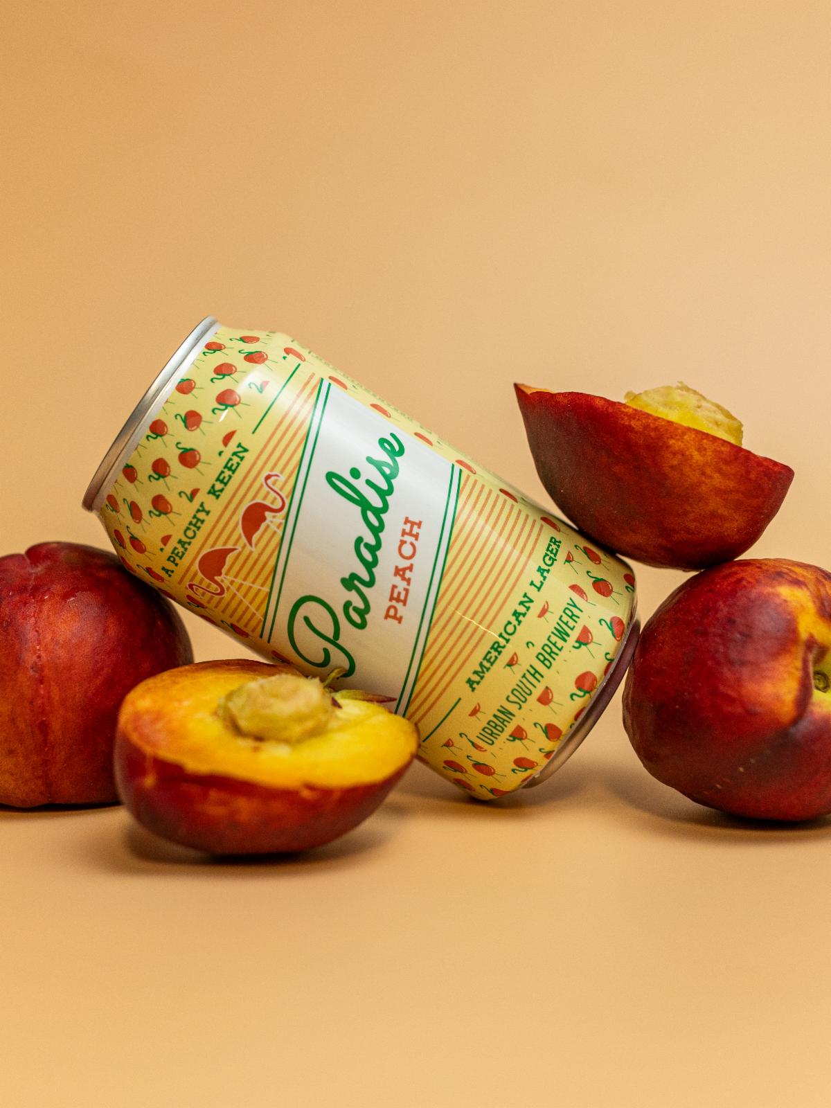 A can of Urban South peach, set against actual peach fruits