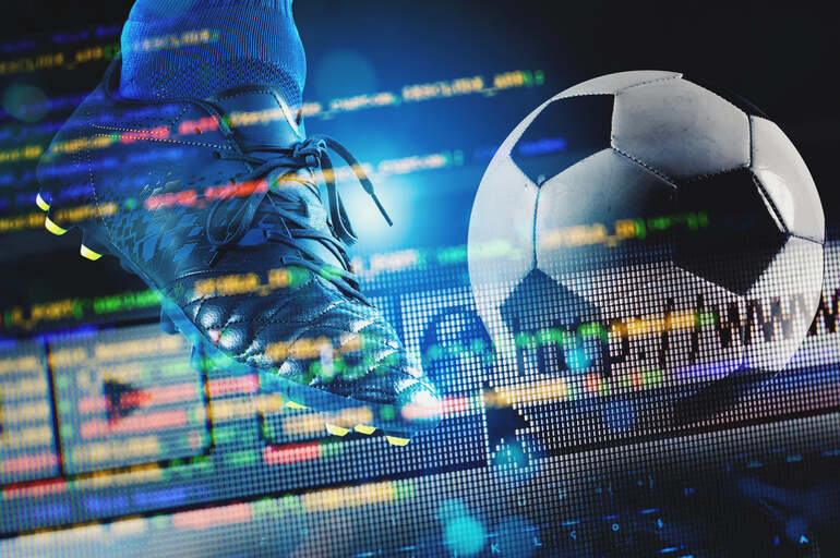 Soccer ball and football boot displayed over sports betting data, representing sports and esports betting strategies.