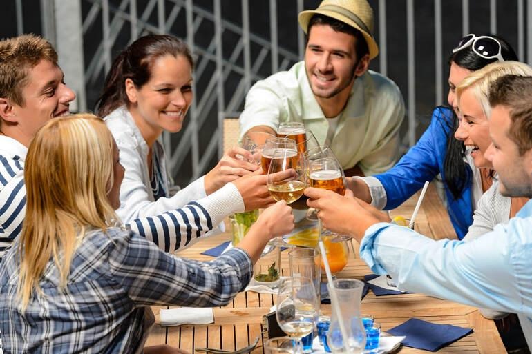 Friends socializing over drinks in a smoke-free modern bar setting.