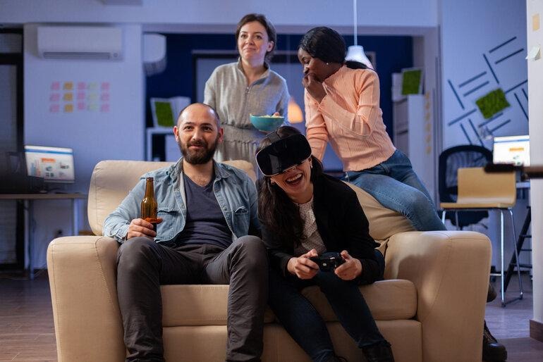 Colleagues enjoying an interactive VR gaming break in an office lounge.