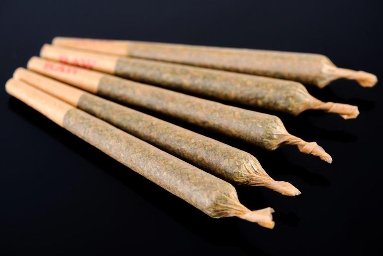 Flavored pre-rolls arranged on a black surface, showcasing options for smokers seeking a smoother taste with less aftertaste in Las Vegas.