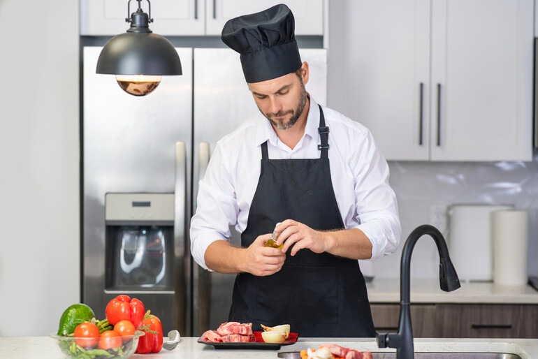 Chef preparing fresh ingredients in a modern kitchen with professional cooking supplies.