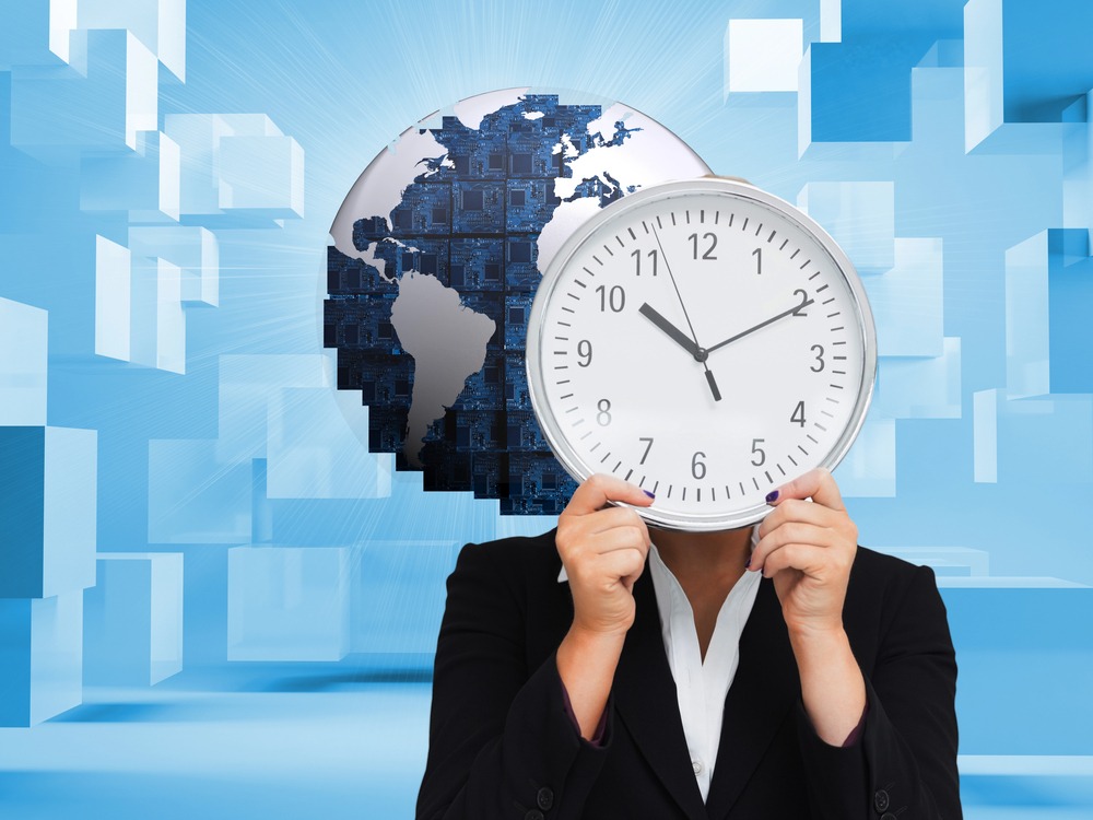 A person holding a large clock face in front of a world globe, symbolizing time zone changes and travel scheduling before competitions.