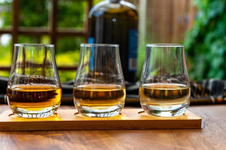 Three glasses of Scotch whisky representing a tasting journey for beer drinkers exploring familiar malt and smoky flavors.
