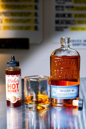 Bulleit 87 whiskey with Mike's Hot Honey rim