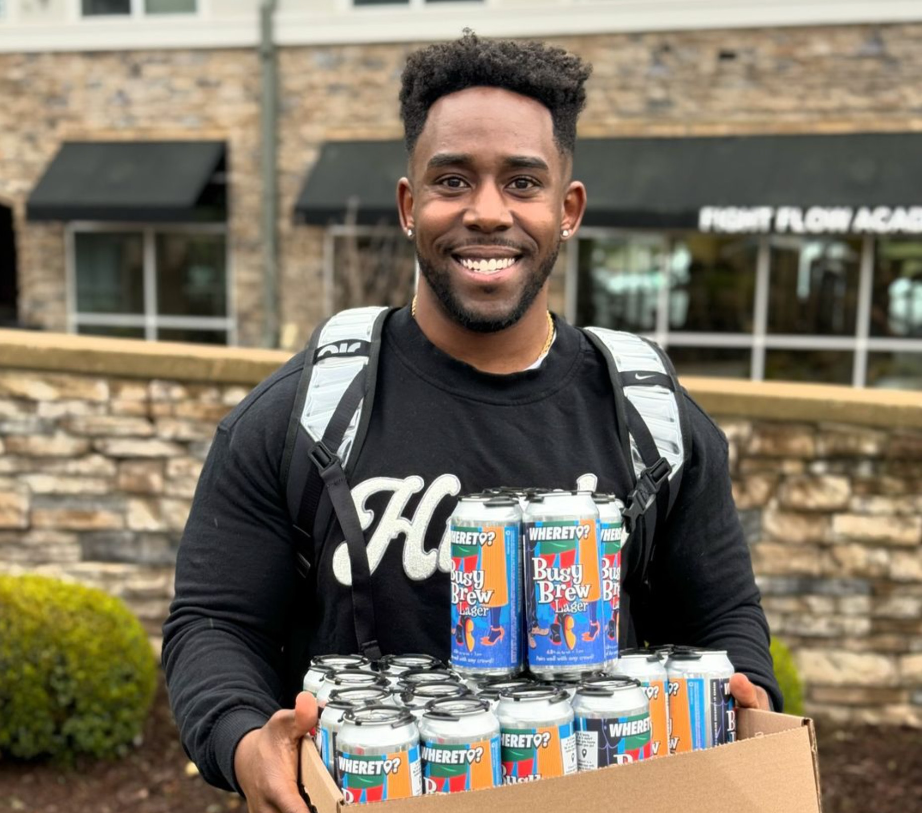 WhereT founder Brandon Lewis holding first case of Busy Brew Lager