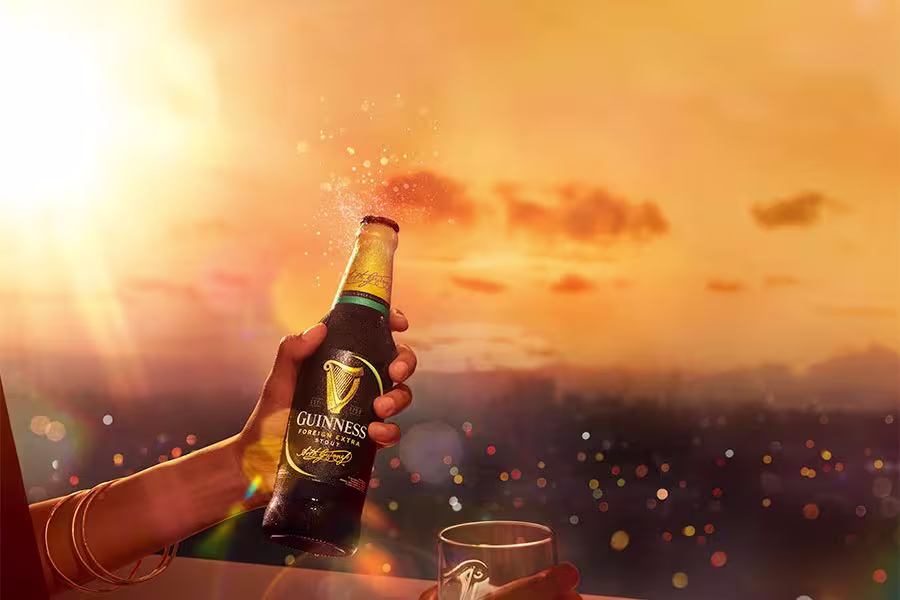 A hand holding a Guinness Foreign Extra Stout bottle.